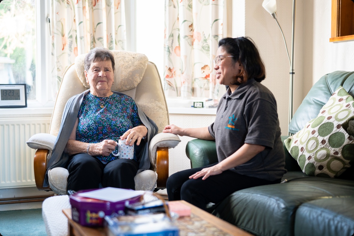 A Seren caregiver talking with a woman in her own home