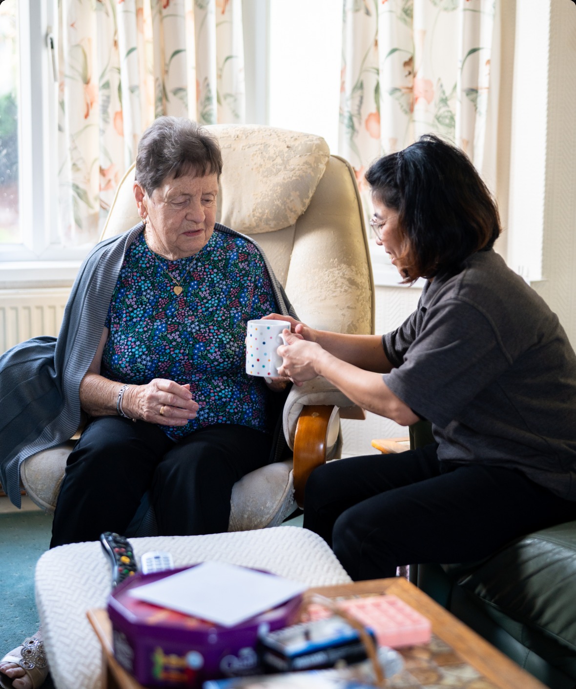 A care professional sharing a warm moment with a client at home