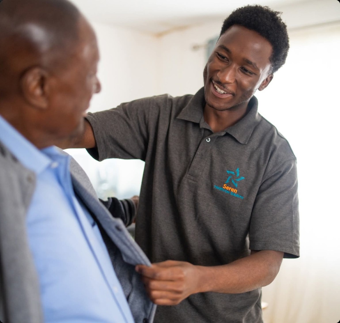 A Seren Healthcare professional helping a client with his cardigan